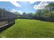 Lush backyard featuring green grass, a wooden deck area, and a home with a brick exterior at 724 Iroquois St, Anderson, IN 46012