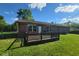 Charming backyard featuring a wooden deck area, a well-kept lawn, and a brick house exterior at 724 Iroquois St, Anderson, IN 46012
