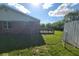 Lush backyard featuring green grass, a wooden deck area, and a brick house at 724 Iroquois St, Anderson, IN 46012