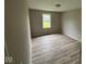 This bedroom is sun-filled with a large window, wood-look floors, and neutral paint at 724 Iroquois St, Anderson, IN 46012