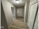 Hallway with wood-look flooring, neutral paint, white trim, and a closet at 724 Iroquois St, Anderson, IN 46012