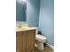 Powder room with standard toilet, sink and light-blue walls at 7532 Perilla Ct, Indianapolis, IN 46237