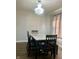 Dining room with dark wood floors and a dark wood table with seating for four, lit by a modern chandelier at 7532 Perilla Ct, Indianapolis, IN 46237