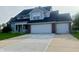 Charming two-story home with a brick facade, a two-car garage, a manicured lawn, and a freshly poured concrete driveway at 7532 Perilla Ct, Indianapolis, IN 46237