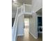 Hallway with white staircase and access to a laundry room featuring a washer and dryer at 7532 Perilla Ct, Indianapolis, IN 46237