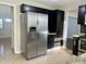 Well-lit kitchen with stainless steel refrigerator and dark cabinets at 7532 Perilla Ct, Indianapolis, IN 46237