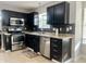 Modern kitchen with stainless steel appliances, black cabinets, granite countertops, and a stylish backsplash at 7532 Perilla Ct, Indianapolis, IN 46237