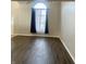 Living room featuring wood floors, a window with decorative curtains, and neutral walls, creating a bright space at 7532 Perilla Ct, Indianapolis, IN 46237