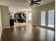 Open-concept living room with hardwood floors, kitchen access, and doors to the outside at 7532 Perilla Ct, Indianapolis, IN 46237