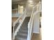 Bright foyer with a carpeted staircase, leading to the second floor with white banisters and modern neutral paint at 7532 Perilla Ct, Indianapolis, IN 46237