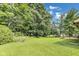 Lush backyard featuring mature trees, a sprawling lawn, and ample space for recreation, relaxation, and entertainment at 7583 Rogers Dr, Indianapolis, IN 46214