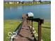 Wooden dock leading to the lake with a covered boat lift and townhomes in the background at 7707 River Rd # 10, Indianapolis, IN 46240