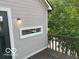 The exterior of the home showing siding, a small outdoor deck, a light fixture and an awning window at 7707 River Rd # 10, Indianapolis, IN 46240