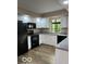 Kitchen with white cabinets, black appliances, and hardwood floors at 7707 River Rd # 10, Indianapolis, IN 46240