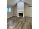 Spacious living room with vaulted ceilings, fireplace, and hardwood floors at 7707 River Rd # 10, Indianapolis, IN 46240
