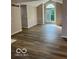 Open-concept living room featuring hardwood flooring and large arched window at 7707 River Rd # 10, Indianapolis, IN 46240