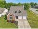 Aerial view of the house featuring a well-manicured lawn and an attached two-car garage at 7766 Jamestown S S Dr, Fishers, IN 46038
