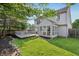 Backyard view shows a large well-manicured lawn, gray deck with lattice, sunroom, and patio at 7766 Jamestown S S Dr, Fishers, IN 46038