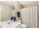 Well-lit bathroom featuring a single vanity, toilet, and bathtub with grey patterned shower curtain at 7766 Jamestown S S Dr, Fishers, IN 46038