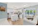 Bright kitchen featuring white cabinets, stainless steel appliances, and an island with seating near the sunroom at 7766 Jamestown S S Dr, Fishers, IN 46038