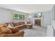 Cozy living room featuring a brick fireplace, a large window, and a comfortable sectional sofa at 7766 Jamestown S S Dr, Fishers, IN 46038