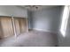 Comfortable bedroom featuring neutral carpet, blue walls, a bright window, and a built in closet or shelving unit at 7879 Main St, Coatesville, IN 46121