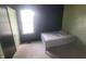Small bedroom with black accent wall and light green walls, carpet, a bed and bright window at 7879 Main St, Coatesville, IN 46121