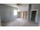 Bright bedroom with neutral carpet, blue walls, a ceiling fan, and built in shelving near the door to another room at 7879 Main St, Coatesville, IN 46121