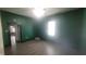 Bright living room with laminated wood flooring and emerald green accent wall at 7879 Main St, Coatesville, IN 46121