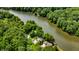 Stunning aerial view of a riverside home nestled among lush trees with a private dock on the water at 8426 N Chickadee Dr, Morgantown, IN 46160