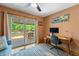 Bright bedroom with a ceiling fan, access to deck, and contemporary desk at 8426 N Chickadee Dr, Morgantown, IN 46160