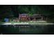 Charming lake house with a dock, deck, and lush greenery reflecting on the water at 8426 N Chickadee Dr, Morgantown, IN 46160