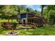 Home's back exterior featuring multi-level decks, a fire pit, and lake access at 8426 N Chickadee Dr, Morgantown, IN 46160