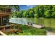 Waterfront home featuring a deck with chairs next to the lake and lush green trees at 8426 N Chickadee Dr, Morgantown, IN 46160