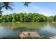 Scenic lake view featuring a dock with lounge furniture and surrounding lush greenery at 8426 N Chickadee Dr, Morgantown, IN 46160