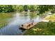 Scenic lake view with a dock featuring lounge furniture and surrounding lush greenery at 8426 N Chickadee Dr, Morgantown, IN 46160