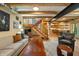 Open-concept living space with wood floors, exposed beams, and modern staircase at 8426 N Chickadee Dr, Morgantown, IN 46160