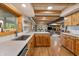 Open-concept living space with exposed beams, modern kitchen, and cozy fireplace at 8426 N Chickadee Dr, Morgantown, IN 46160