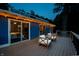 Evening deck with sliding glass doors, modern chairs, and ambient lighting for serene relaxation at 8426 N Chickadee Dr, Morgantown, IN 46160