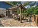 Charming outdoor patio featuring a pergola, dining set, and stone floor overlooking the serene lake at 8426 N Chickadee Dr, Morgantown, IN 46160