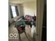 Bedroom featuring a bed, window with curtains, chair, and personal fan, creating a living space at 8457 Kousa Dr, Indianapolis, IN 46234