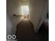 Carpeted staircase leading to a bright entrance with a white door, offering a welcoming feel at 8457 Kousa Dr, Indianapolis, IN 46234