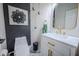Stylish powder room with modern fixtures, gold accents, and a decorative dark accent wall at 8703 Gordonshire Dr, Indianapolis, IN 46278