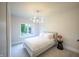 Minimalist bedroom with large window, gray cushioned bed frame, modern light fixture, and carpet at 8703 Gordonshire Dr, Indianapolis, IN 46278