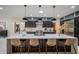 Modern kitchen features an island with seating, pendant lights, stainless steel appliances, and dark wood cabinets at 8703 Gordonshire Dr, Indianapolis, IN 46278