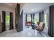 Modern living room with fireplace, marble floors, stylish chairs, and natural light from the large surrounding windows at 8703 Gordonshire Dr, Indianapolis, IN 46278