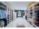 Spacious walk-in closet with custom shelving and storage, a large window, and an ottoman at 8703 Gordonshire Dr, Indianapolis, IN 46278