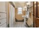 Well-lit bathroom with yellow tile, a pedestal sink, and a tiled floor at 948 N Layman Ave, Indianapolis, IN 46219