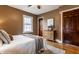 A comfortable bedroom with a decorative dresser, hardwood floors, two doors, and a large window at 948 N Layman Ave, Indianapolis, IN 46219