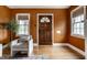 Warm entryway featuring hardwood floors, an inviting wooden door, and natural light from two windows at 948 N Layman Ave, Indianapolis, IN 46219